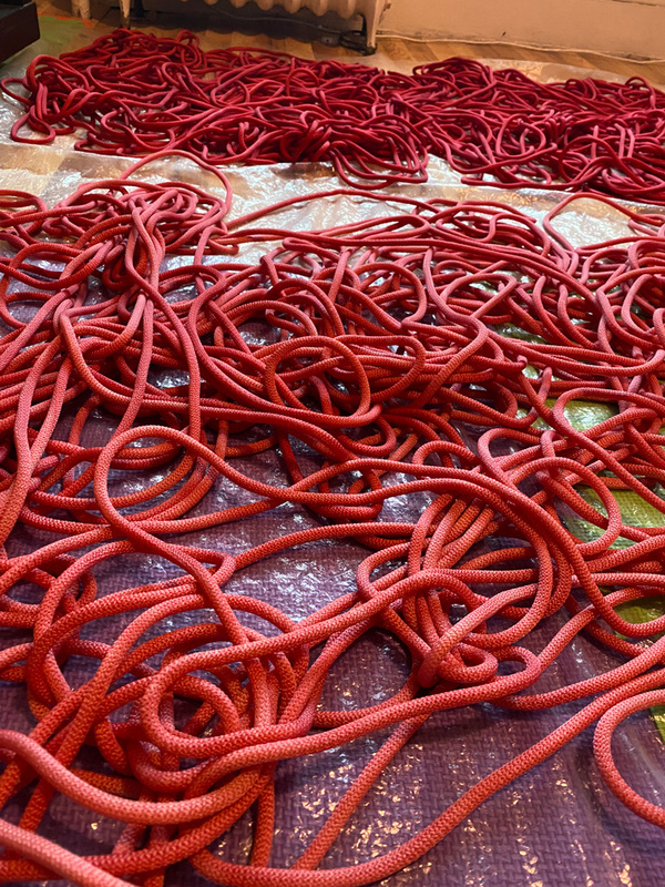 Dyed red nylon rope drying on the floor